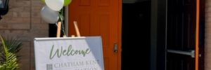 Orange front door open wide with sign and balloons welcoming CKAR members
